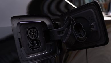 Close-up image of an electric vehicle charging port on a black car.