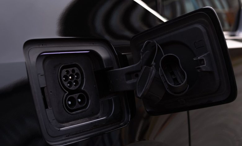 Close-up image of an electric vehicle charging port on a black car.