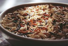 Macro shot of a ceramic bowl filled with colorful mixed wild rice, highlighting textures.