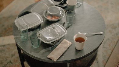 A cozy home setting with a table covered in takeaway food containers and used dishes.