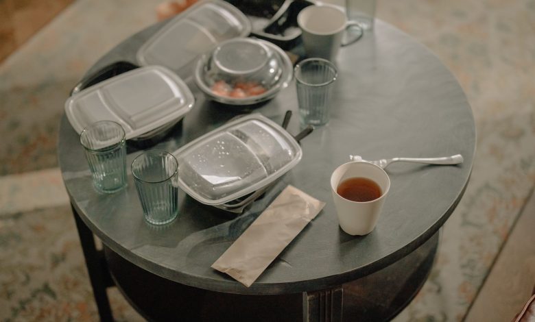 A cozy home setting with a table covered in takeaway food containers and used dishes.