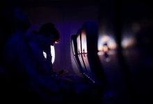 Passengers resting in a dimly lit airplane with purple ambient lighting, showcasing a peaceful travel experience.
