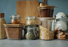 Stylish pantry setup with a variety of foods in glass storage jars, showcasing dry goods and cookies.