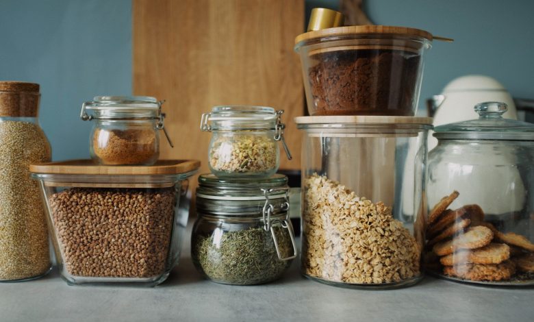 Stylish pantry setup with a variety of foods in glass storage jars, showcasing dry goods and cookies.