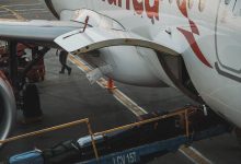 Close-up view of luggage being loaded onto an airplane at the airport.