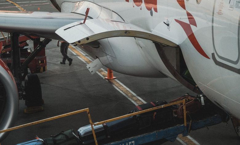 Close-up view of luggage being loaded onto an airplane at the airport.