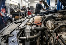 Car engine cooling system inspection showing radiator cap and coolant reservoir tank