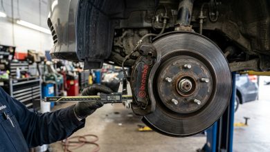 Close-up of a mechanic measuring car disc brake caliper and rotor wear